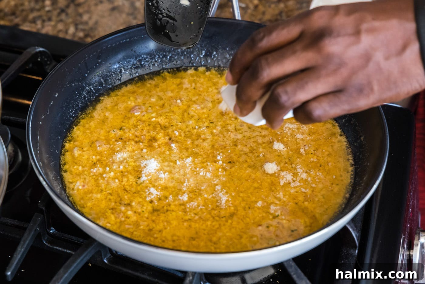 Golden Lobster Indulgence 14 sprinkling parmesan cheese into thermidor sauce