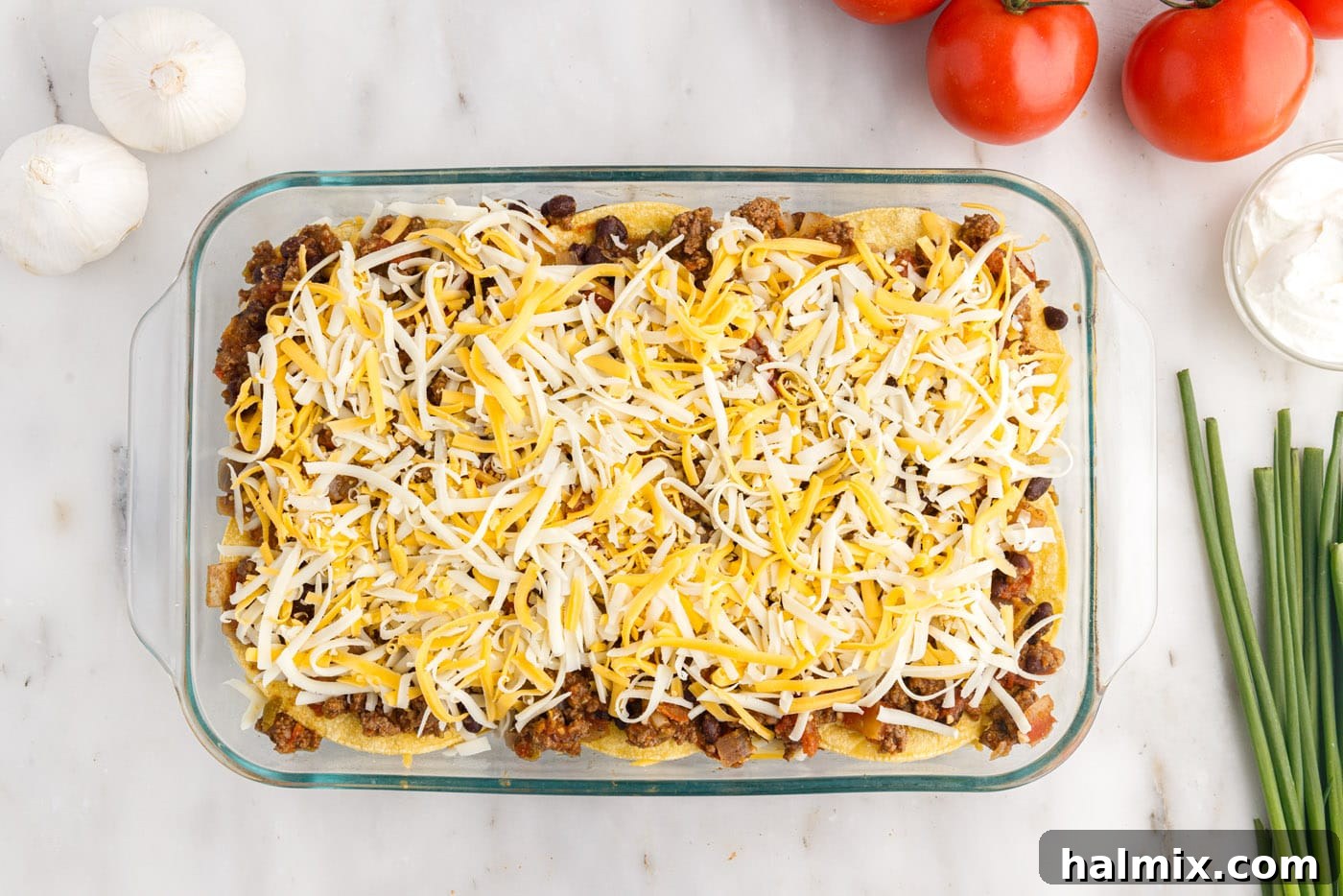 Shredded cheese generously sprinkled on top of the corn tortillas and beef mixture, promising gooey delight