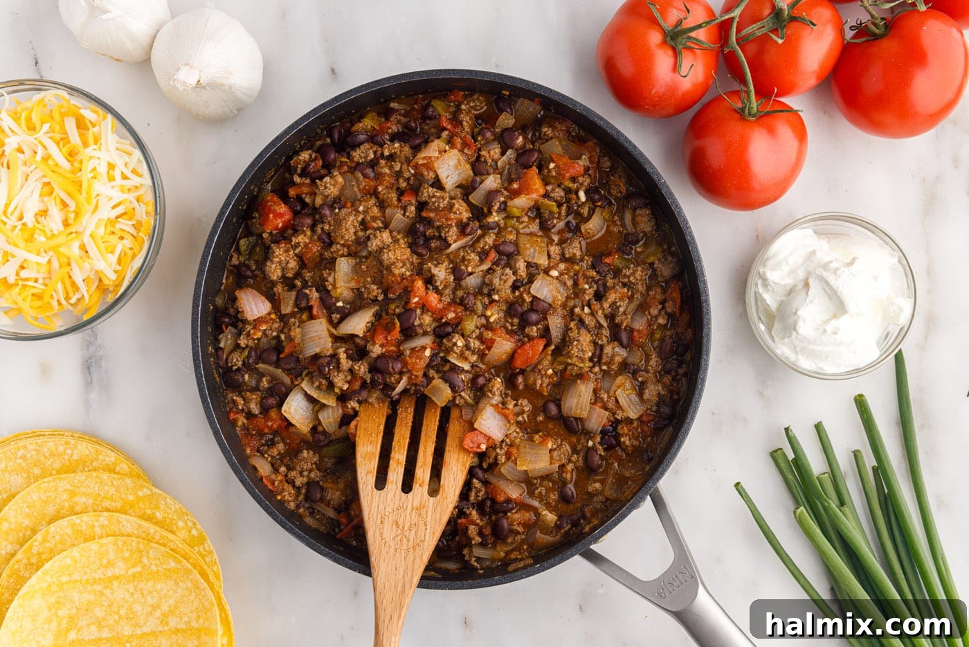 The fully combined Mexican lasagna ground beef mixture simmering in a skillet, rich and ready for layering