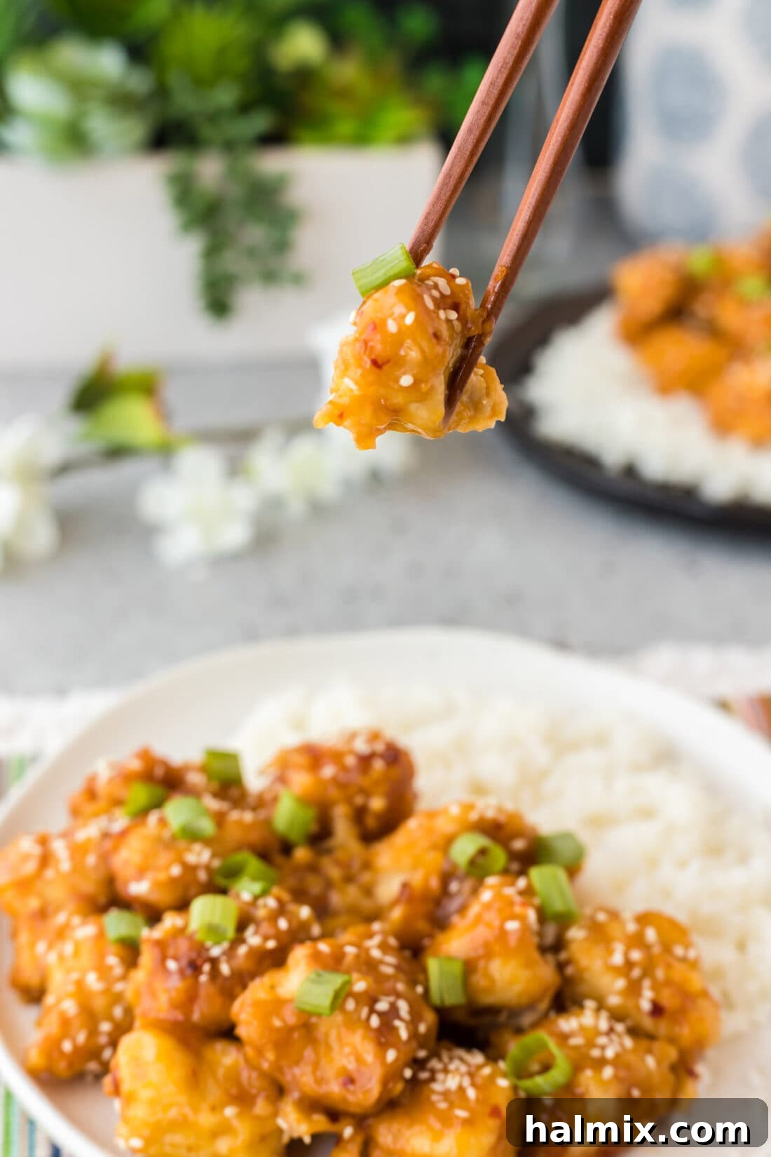 Piece of Orange Chicken in chopsticks