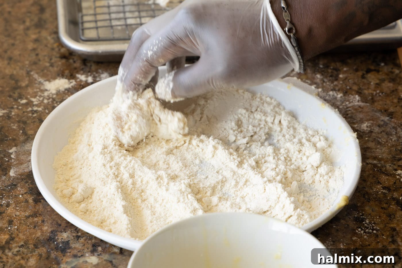 dipping chicken into flour