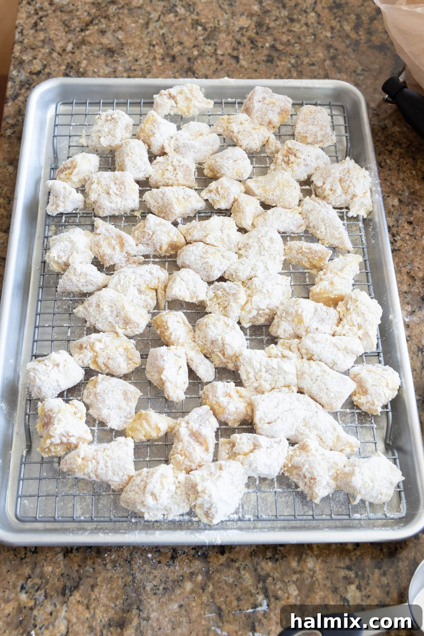 flour and egg dredged chicken pieces on a wire rack