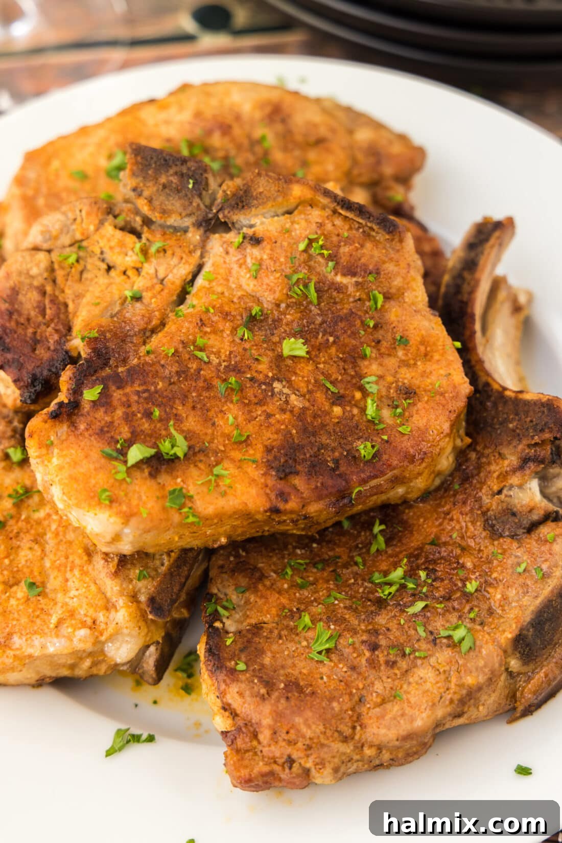 Tender Instant Pot Pork Chops 2 Plate of perfectly cooked Instant Pot Pork Chops, garnished and ready to serve.