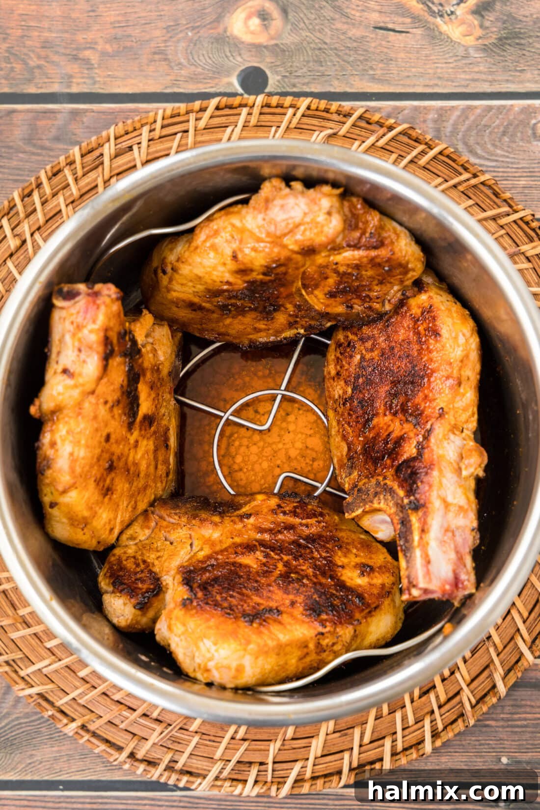 Tender Instant Pot Pork Chops 3 Two perfectly seared pork chops resting in an Instant Pot before pressure cooking.