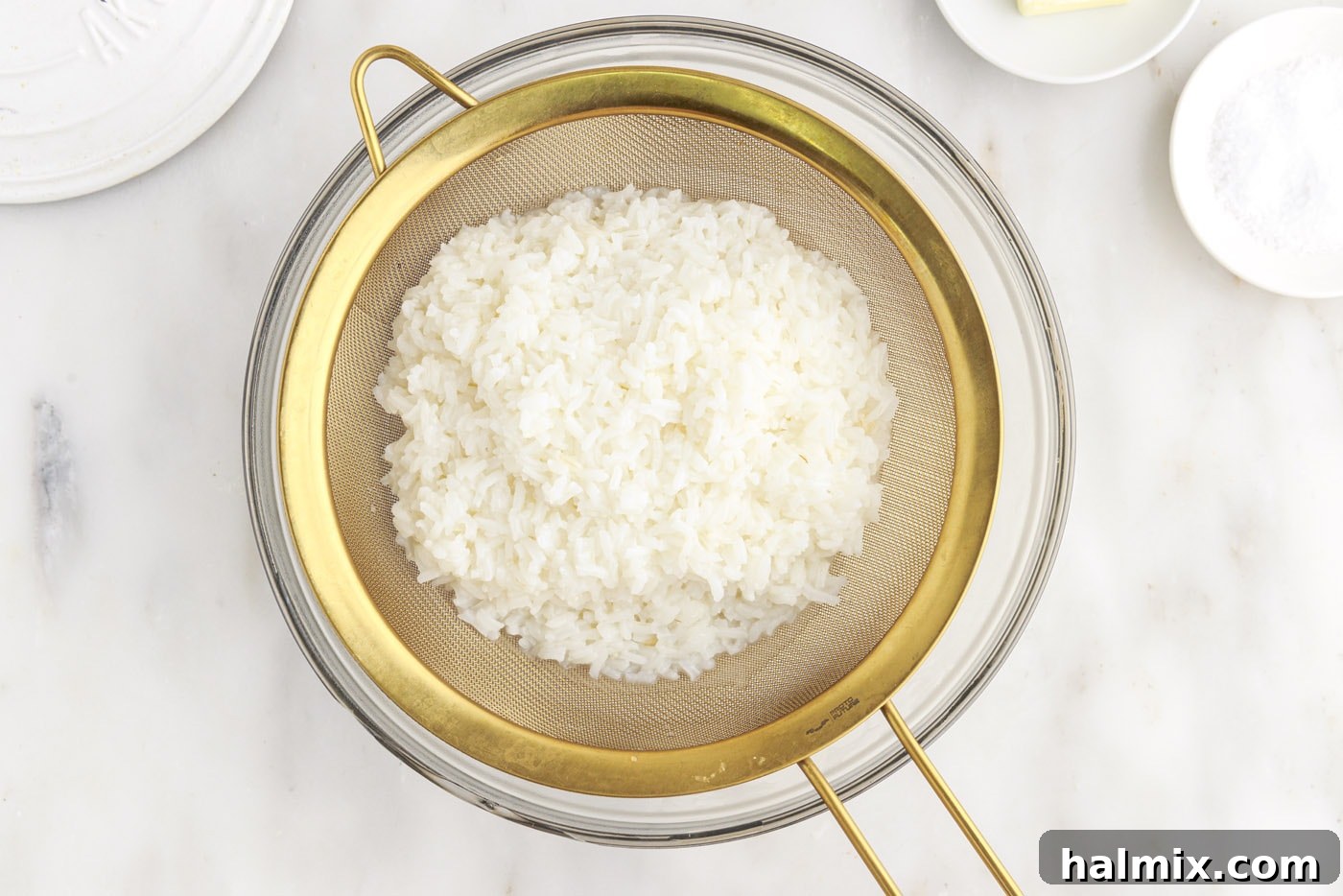Draining cooked rice through a sieve into a bowl