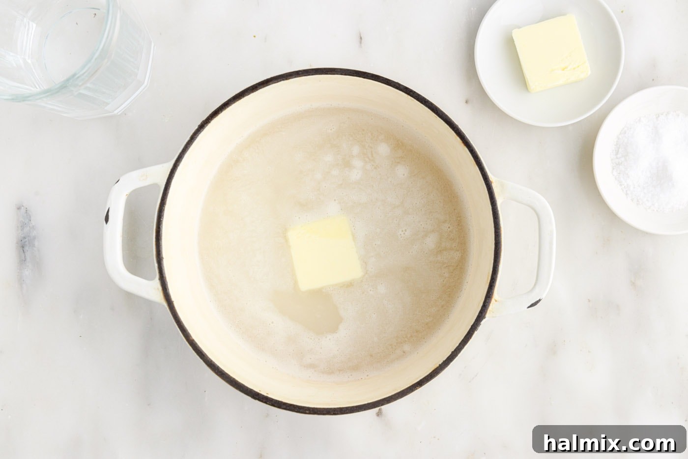 Butter added to the rice and water in a saucepan