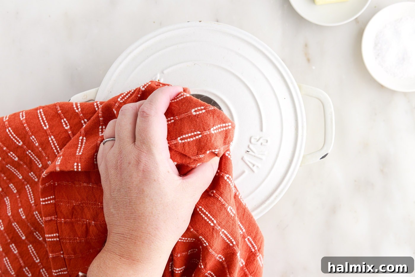Placing the lid over rice and water in a pot after it starts boiling