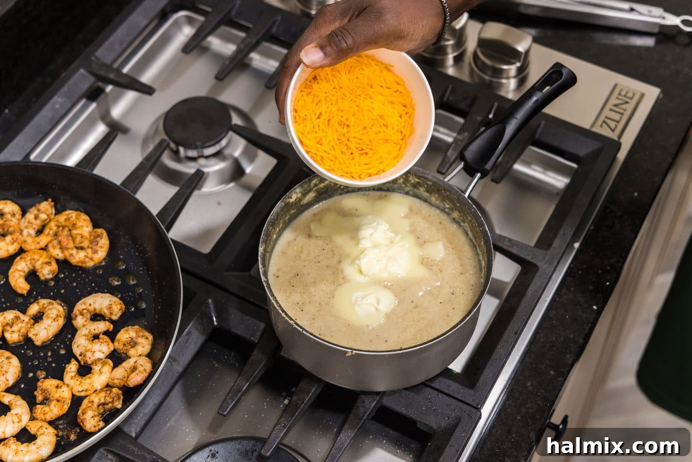 Sprinkling shredded cheddar cheese over the warm grits in a saucepan to create cheesy grits.