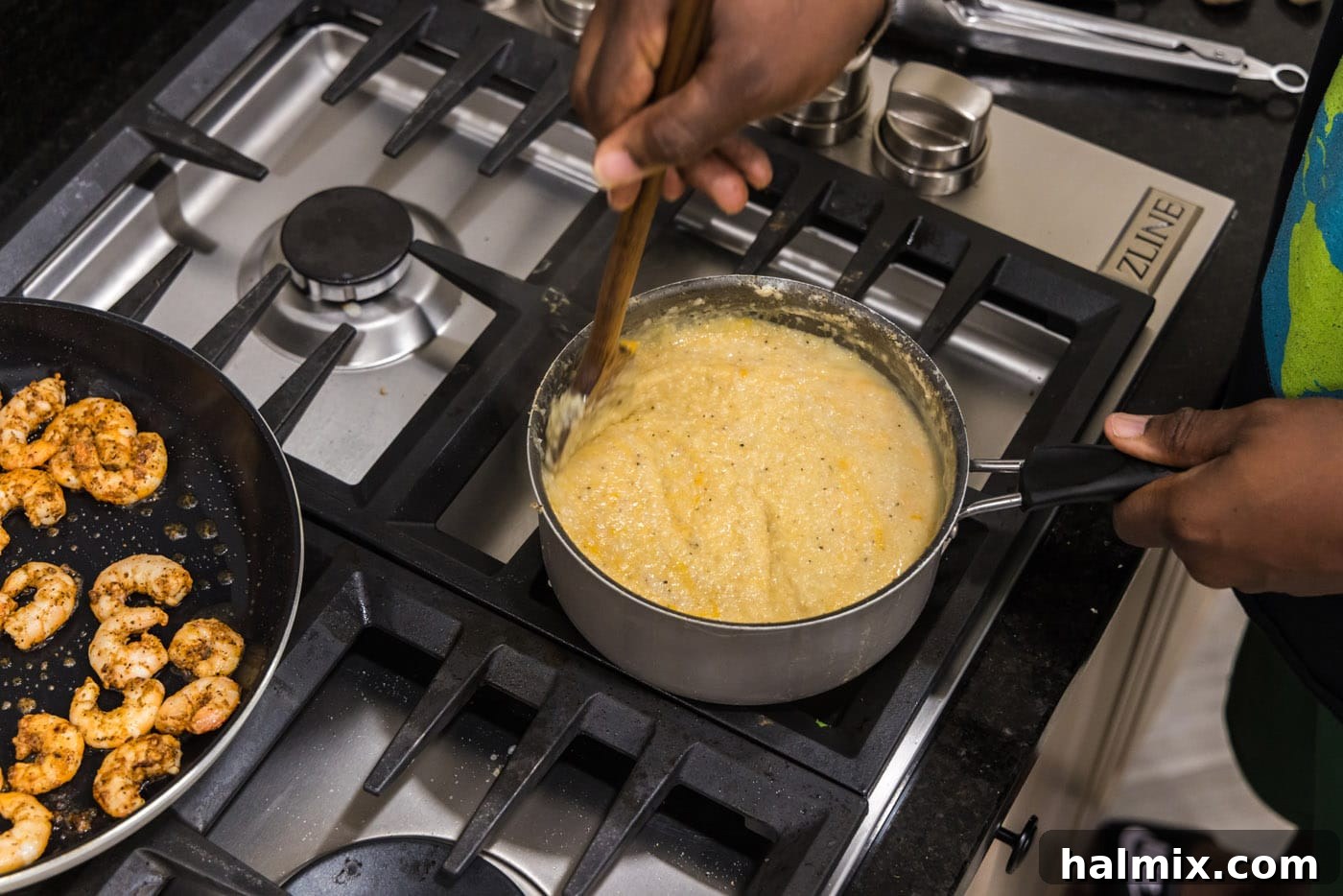 Stirring butter and cheddar cheese into the grits until melted and fully combined, creating a creamy, cheesy consistency.