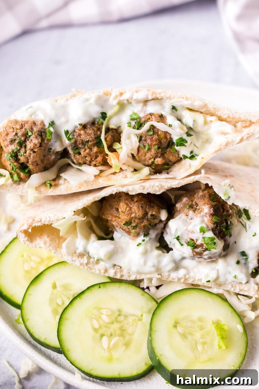 Juicy Lamb Meatballs served in a warm pita pocket with creamy tzatziki sauce and fresh herbs.
