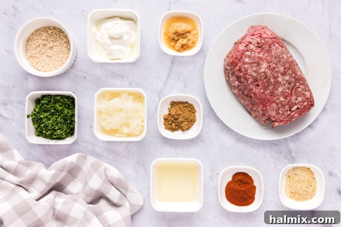 A selection of fresh ingredients including ground lamb, Greek yogurt, herbs, and spices laid out on a kitchen counter, ready for making lamb meatballs.