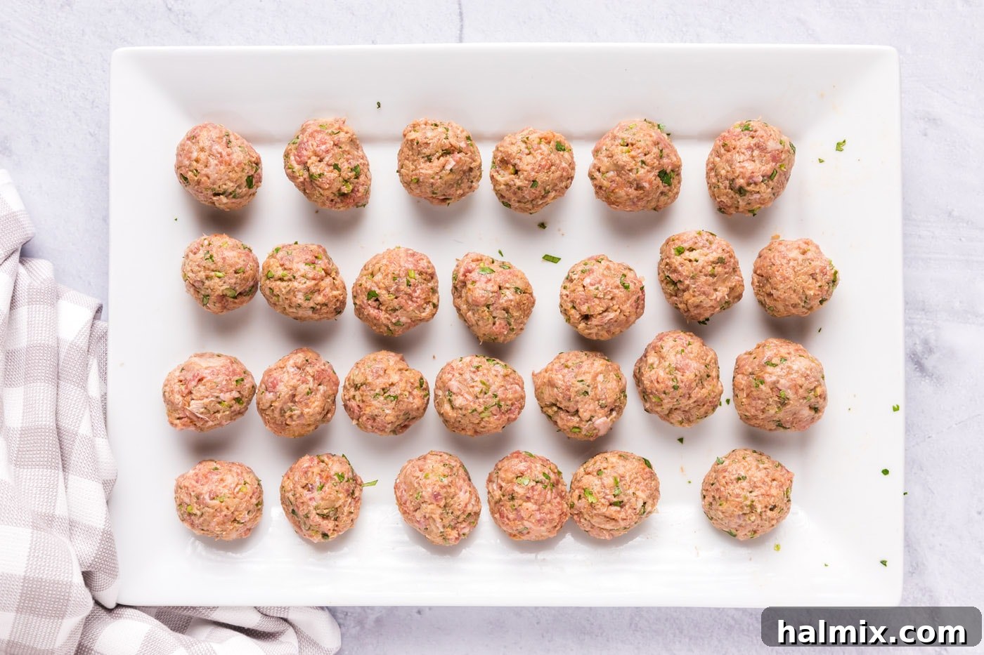 Perfectly rolled lamb meatballs arranged neatly on a baking tray, ready for the searing process.