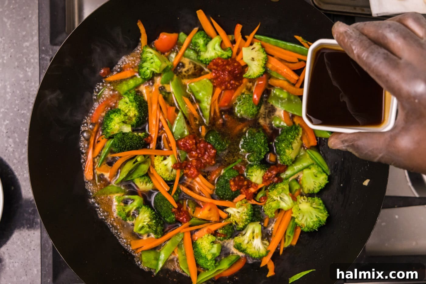 adding soy sauce to stir fried vegetables