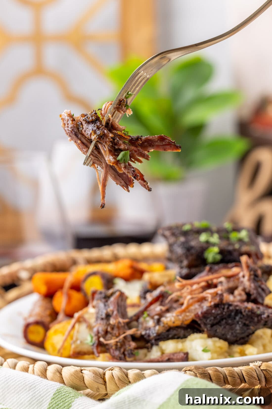 Fall-Off-The-Bone Beef Ribs 11 A forkful of tender Beef Short Rib, showing the juicy, pulled meat, garnished with fresh parsley.