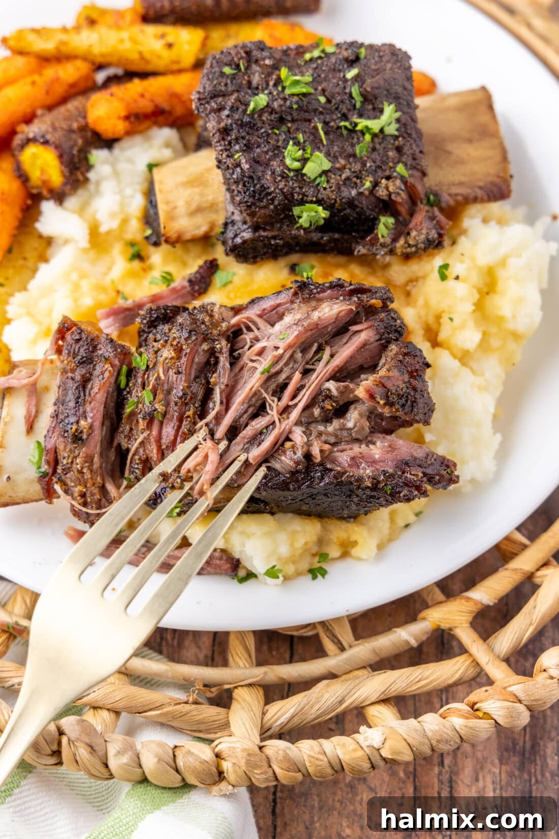 Fall-Off-The-Bone Beef Ribs 3 Close up of a Beef Short Rib pulled apart with a fork, showcasing its incredible tenderness and juicy texture.