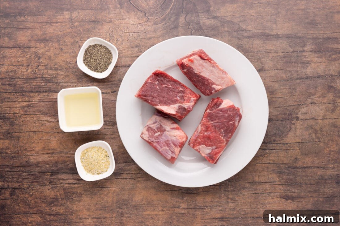 Fall-Off-The-Bone Beef Ribs 4 A flat lay of ingredients for Beef Short Ribs: short ribs, olive oil, garlic salt, and black pepper, arranged on a rustic wooden board.