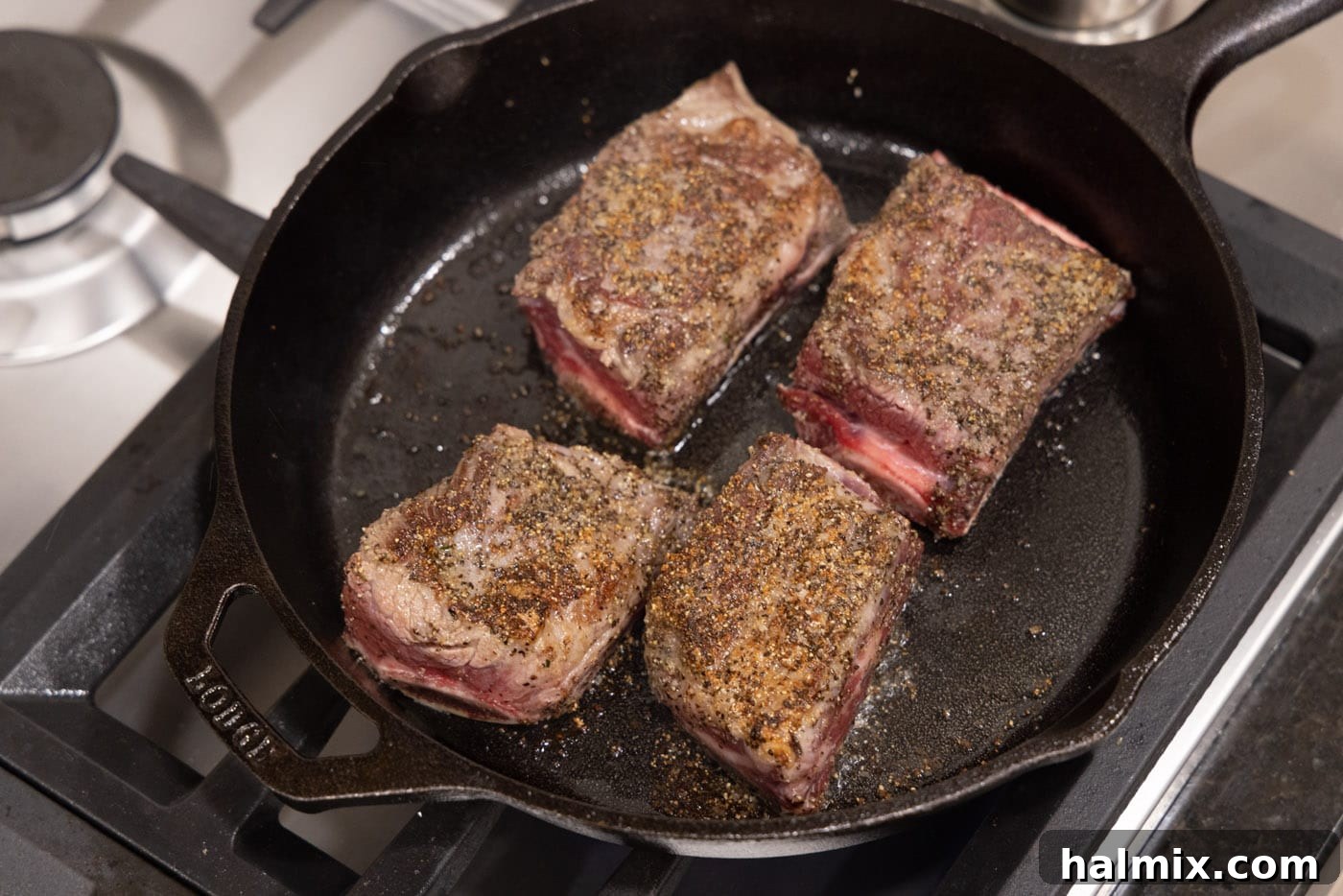 Fall-Off-The-Bone Beef Ribs 8 Perfectly browned beef short ribs resting in the skillet after searing.
