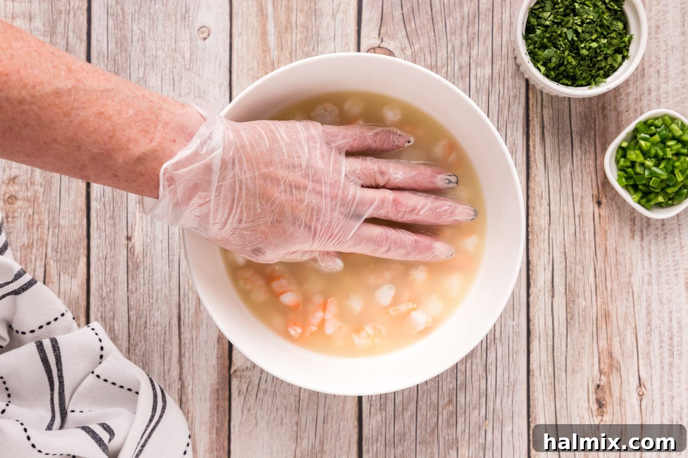Zesty Shrimp Ceviche 11 hand pressing down on shrimp in a bowl with citrus juice