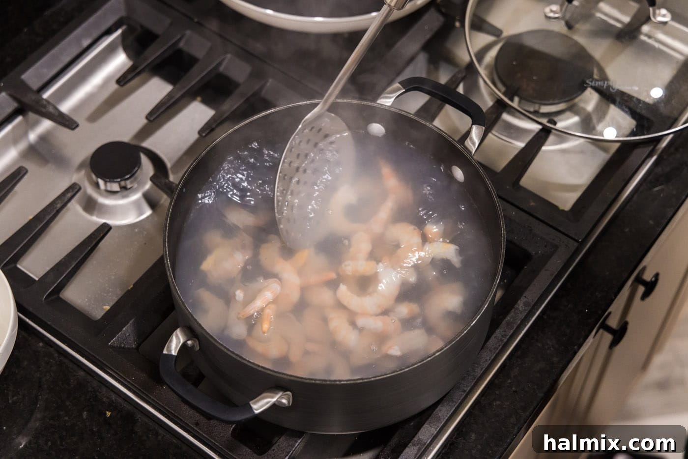 Zesty Shrimp Ceviche 7 removing shrimp from hot water with a slotted spoon