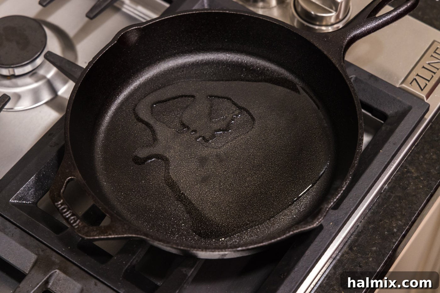 Olive oil shimmering brightly in a hot cast-iron skillet, indicating it has reached the ideal temperature for searing steaks.