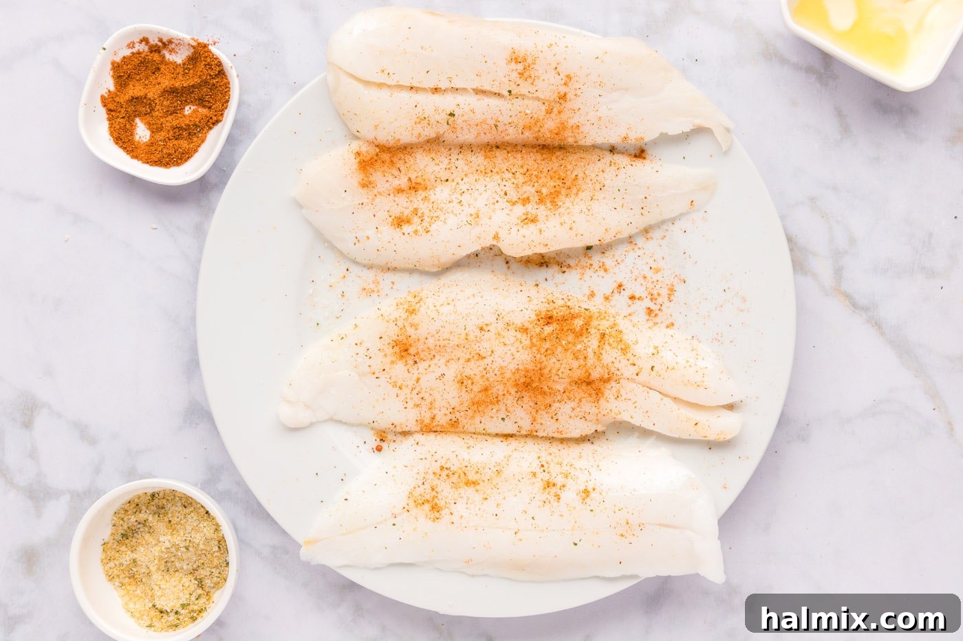 Ocean's Ancient Dweller 6 Two orange roughy fillets perfectly seasoned with Old Bay seasoning, ready for cooking.