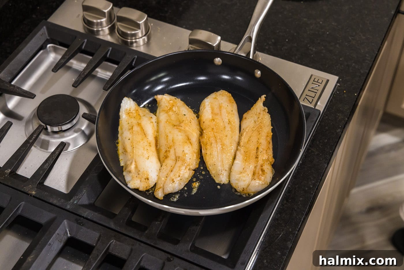 Ocean's Ancient Dweller 8 Orange roughy fillets sizzling in a hot skillet, developing a golden crust.