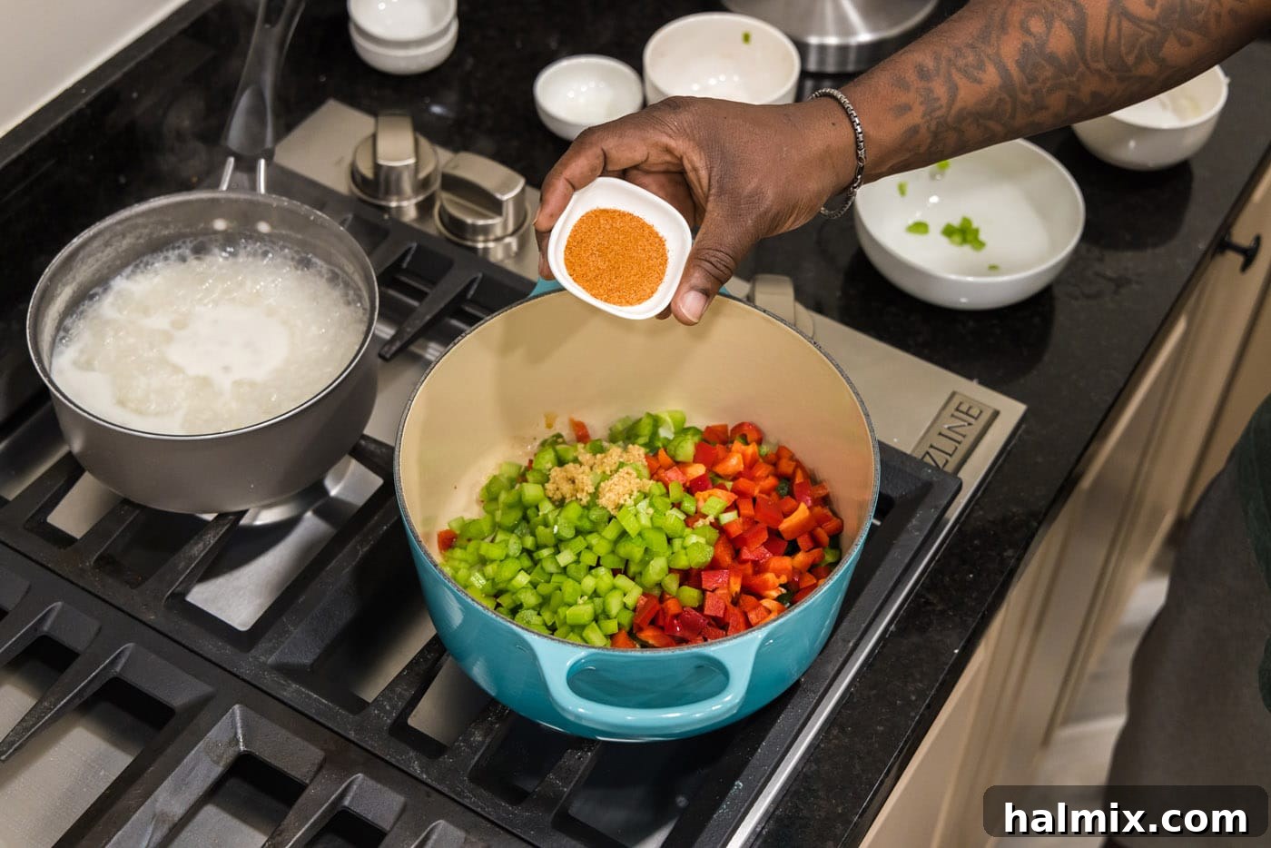 Bayou Blend 5 A hand adding Cajun seasoning to a mixture of diced bell peppers, celery, onion, and garlic sautéing in a Dutch oven.