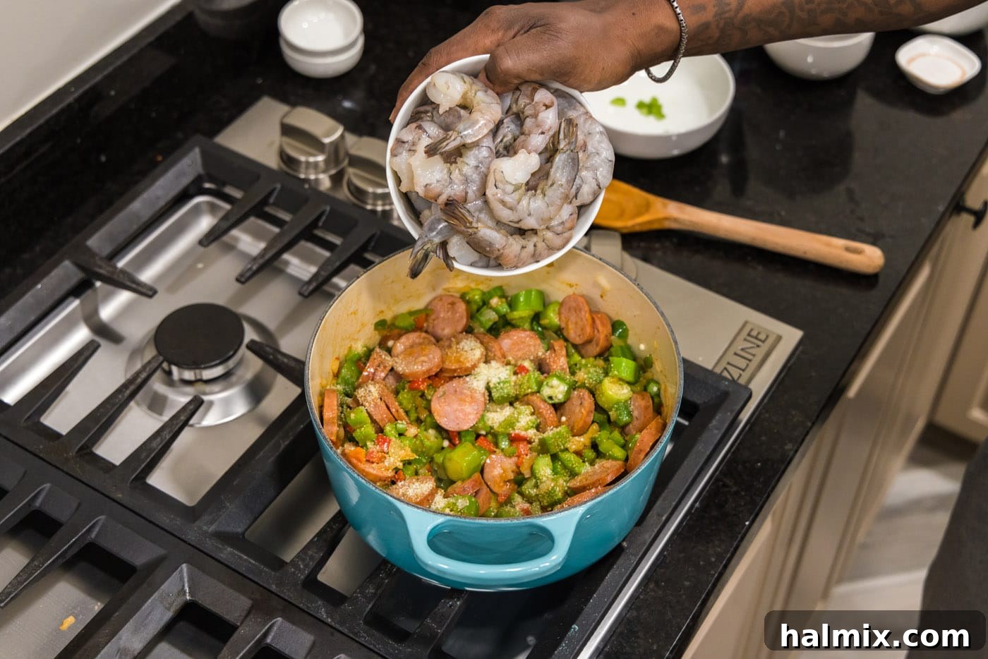 Bayou Blend 10 Fresh shrimp being carefully placed into the pot with the smoked sausage and Holy Trinity vegetables.