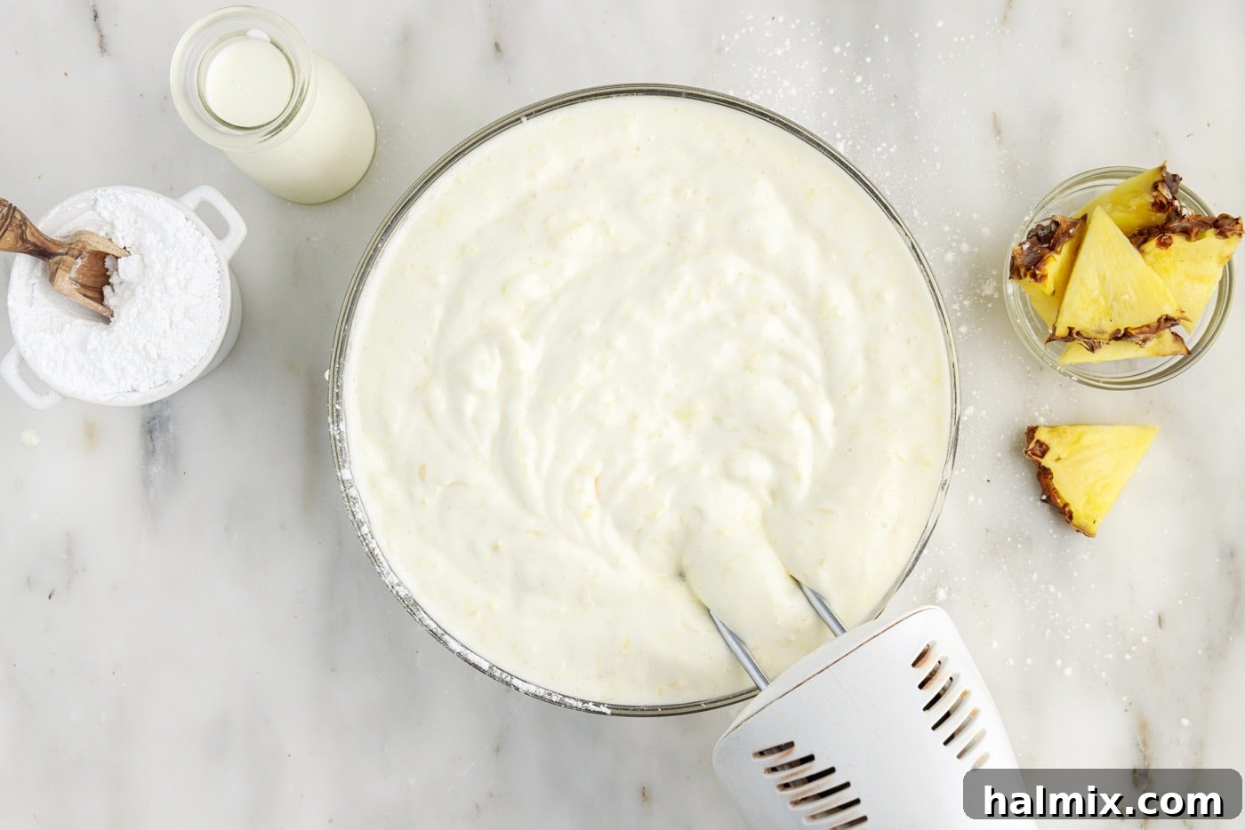 hand mixer combining crushed pineapple and angel food cake mix