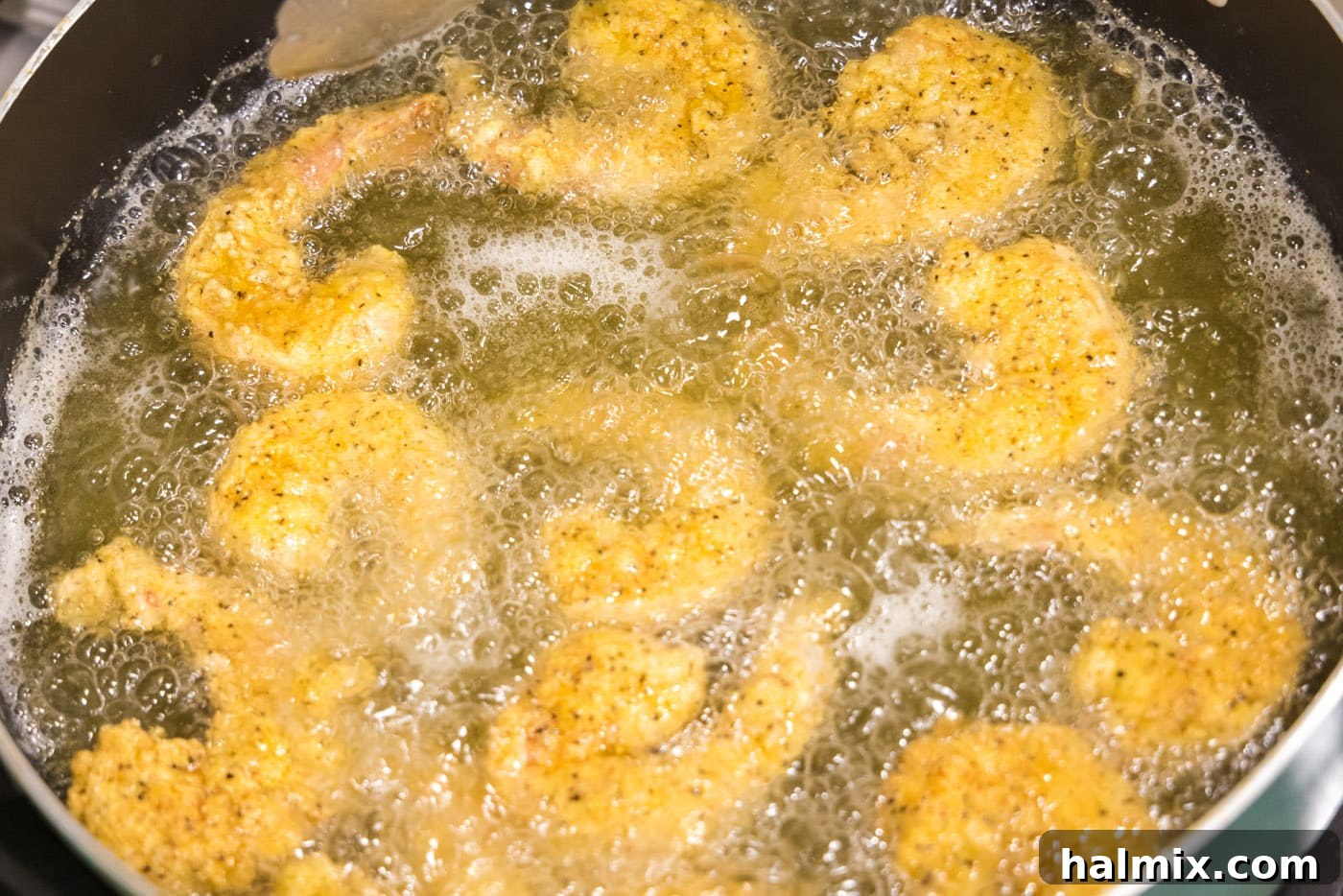 fried shrimp cooked in oil on the stovetop
