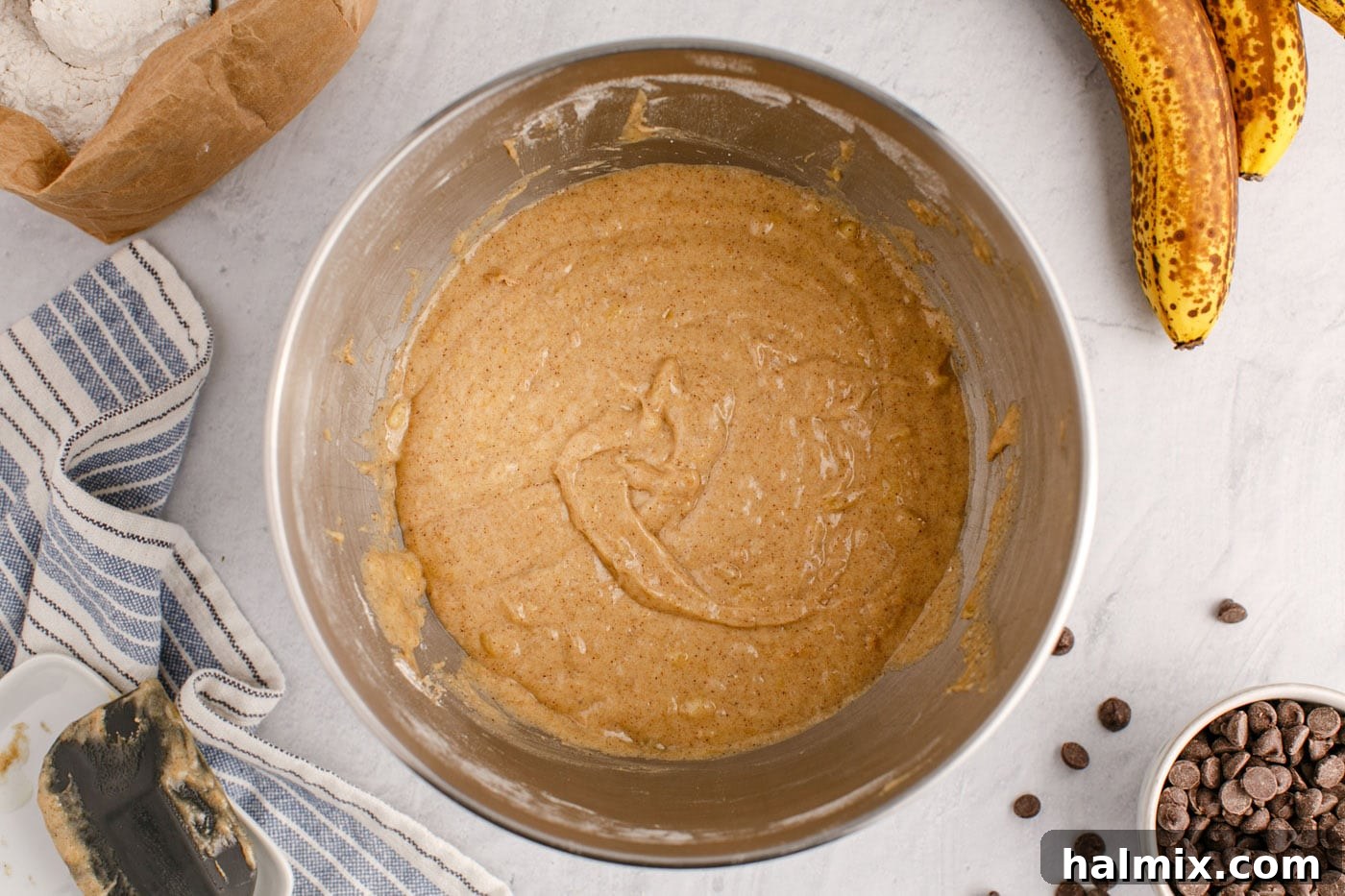 Ultimate Chocolate Chip Banana Bread 10 The banana bread batter in a mixing bowl after dry ingredients have been partially combined, showing a thick, uniform mixture.