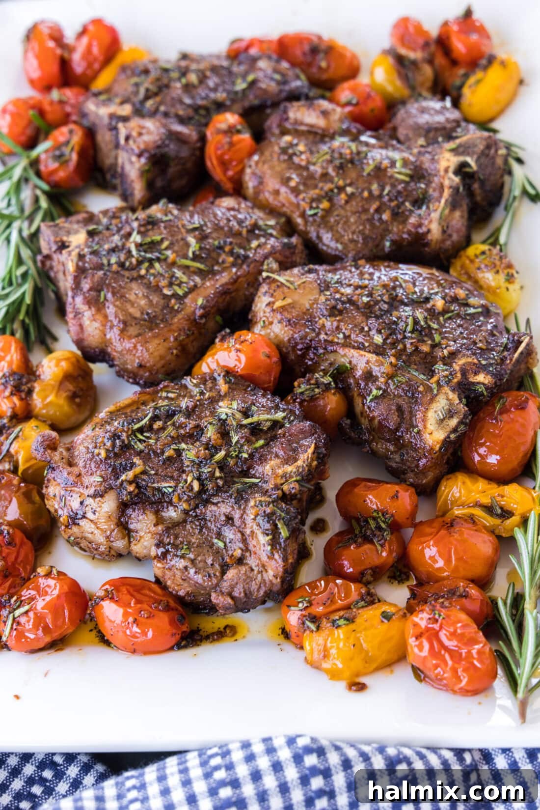Platter of artfully arranged pan-seared lamb loin chops garnished with fresh rosemary sprigs, ready to serve