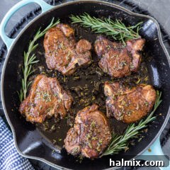 Close-up of perfectly pan-seared lamb loin chops in a skillet, ready to serve