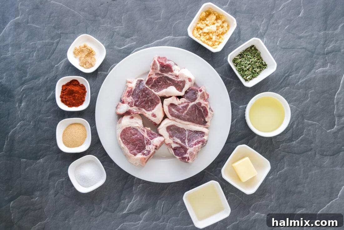 Assortment of fresh ingredients for Pan-Seared Lamb Loin Chops, including lamb, rosemary, garlic, and various spices