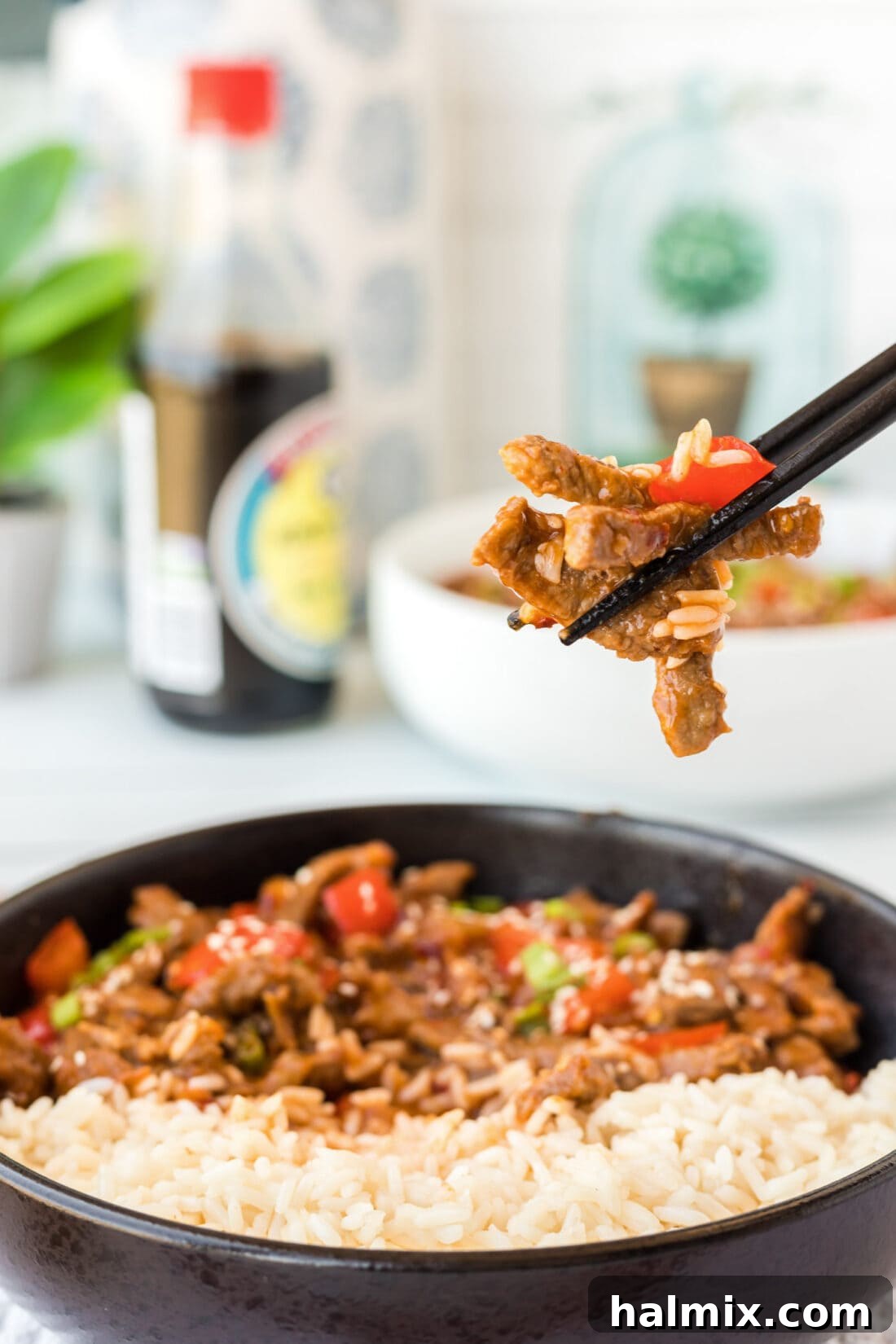 Pieces of Beijing Beef held in chopsticks 