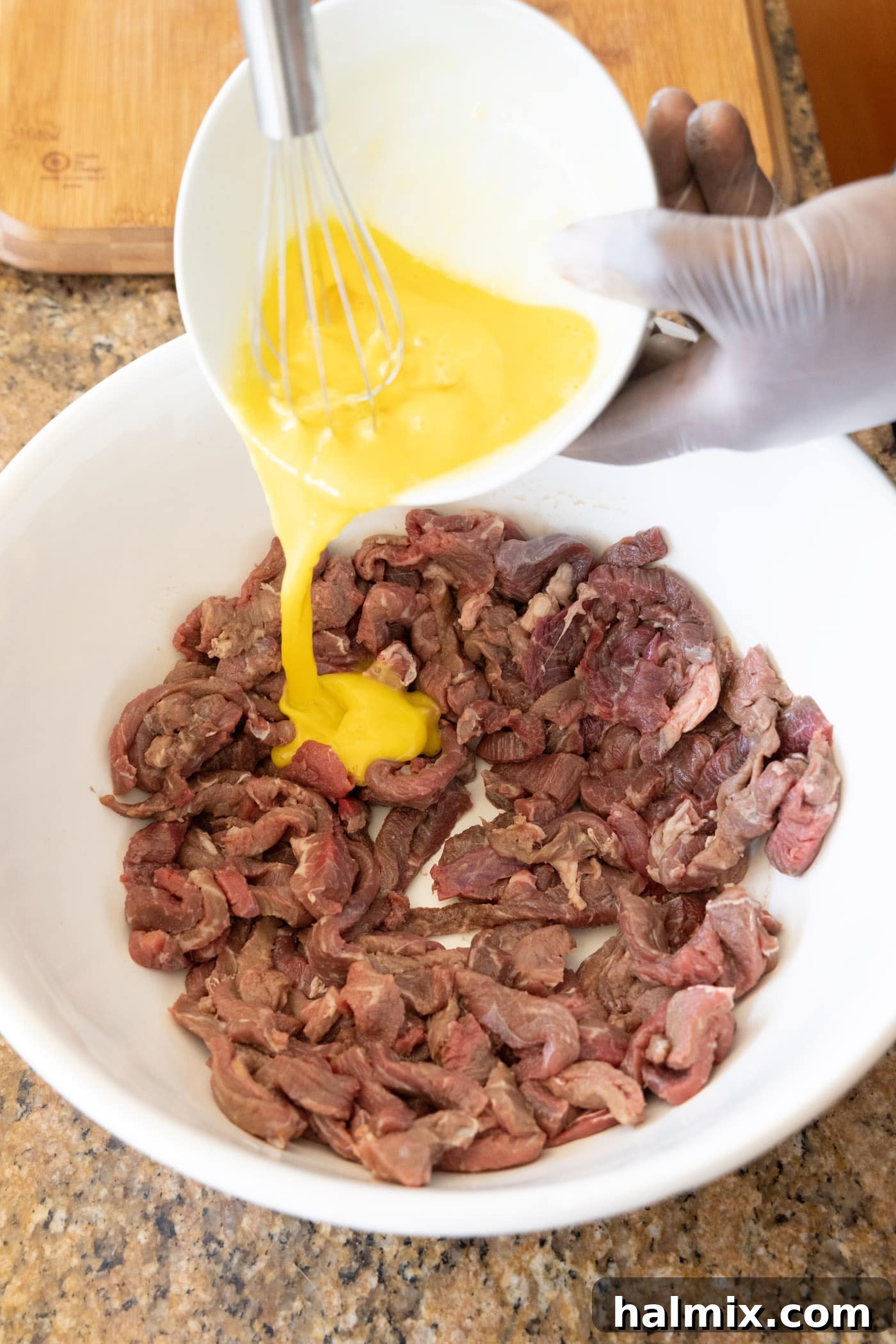 pouring egg over sliced flank steak