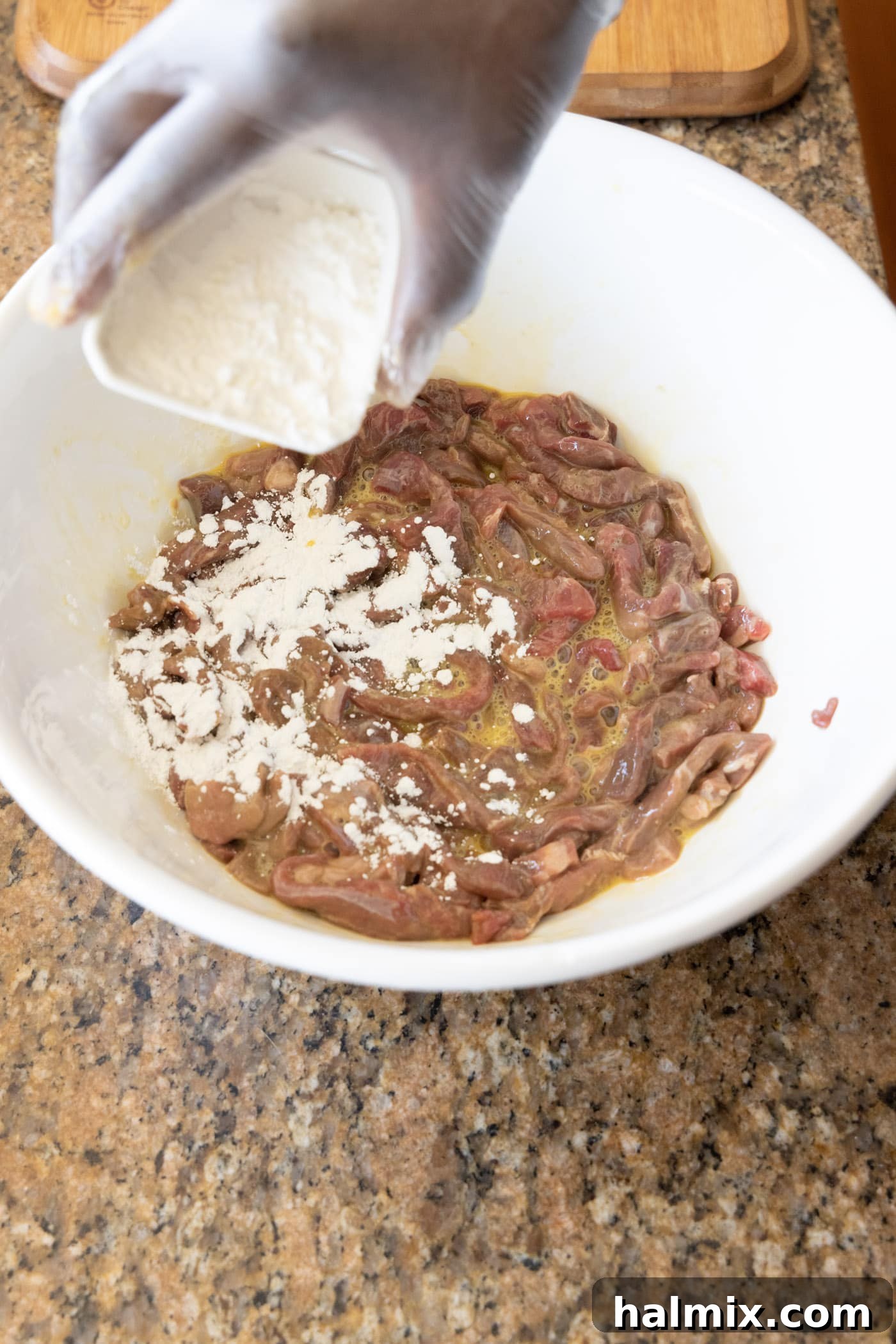 adding cornstarch to egg and beef mixture in a bowl