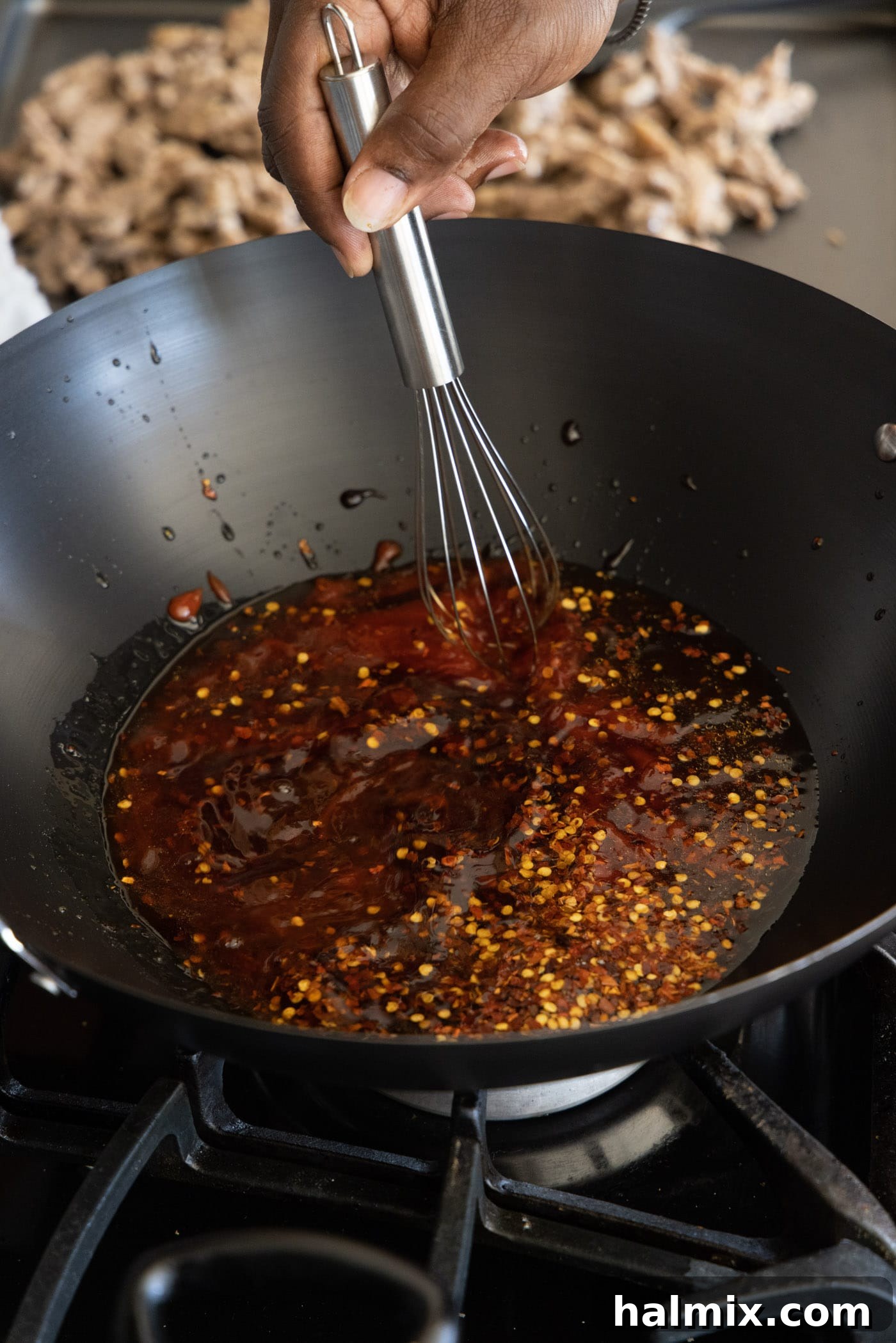 whisking beijing beef sauce in a wok