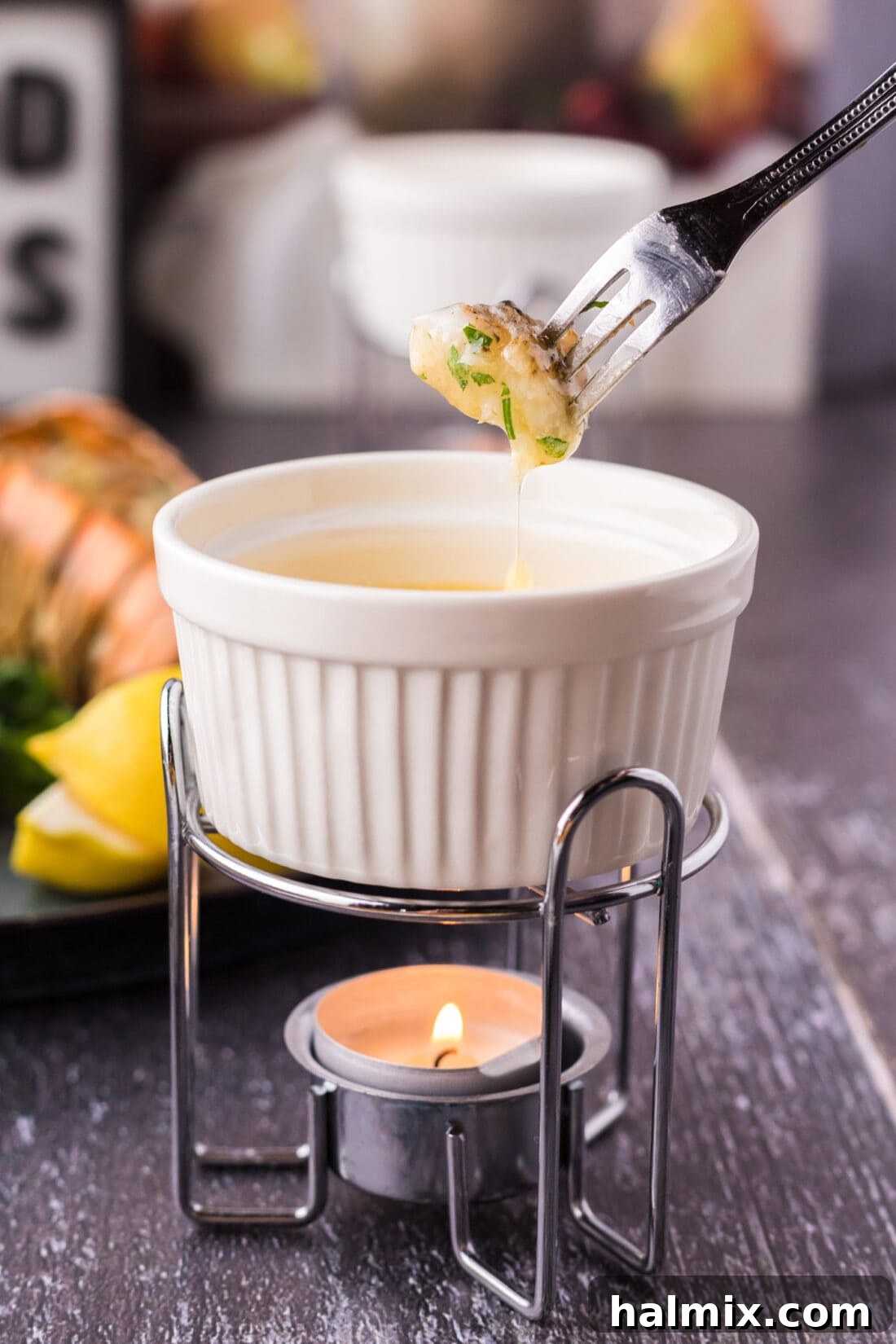 A succulent piece of grilled lobster tail, dipped in melted butter, ready to be enjoyed.