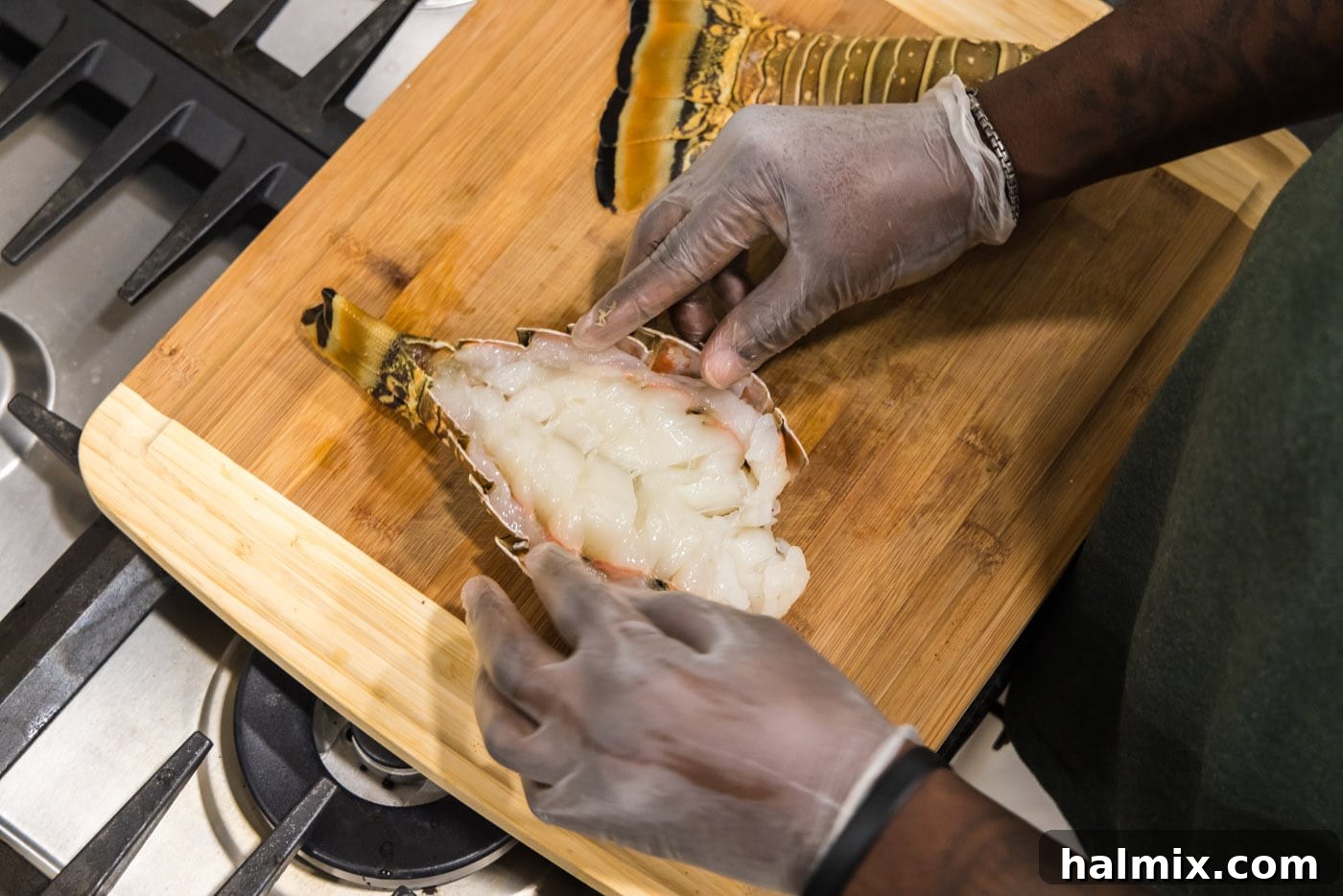 The process of breaking open a lobster tail to expose the delicious meat, ready for seasoning.