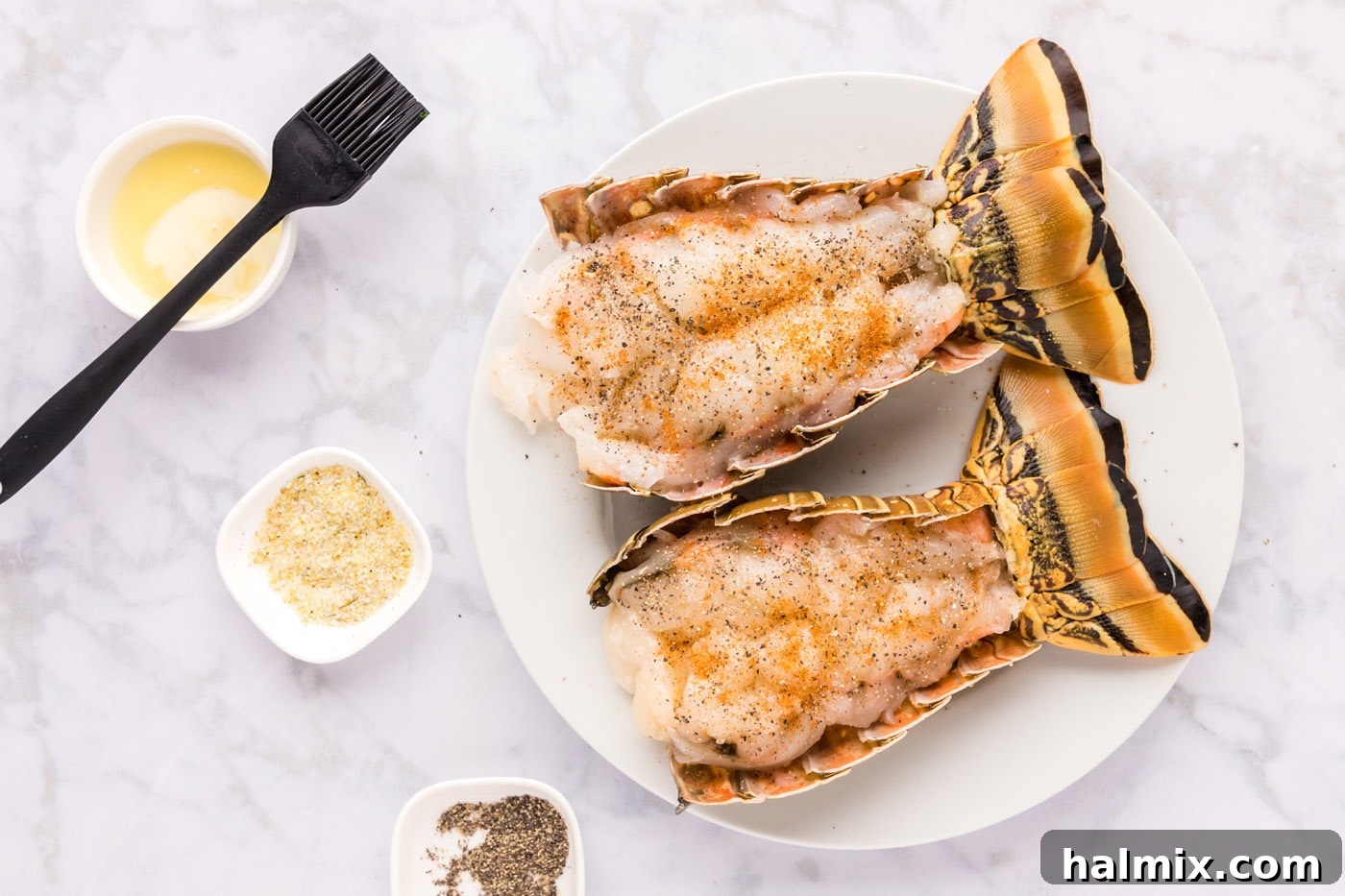 Close-up of butterflied lobster tail meat generously seasoned with spices.