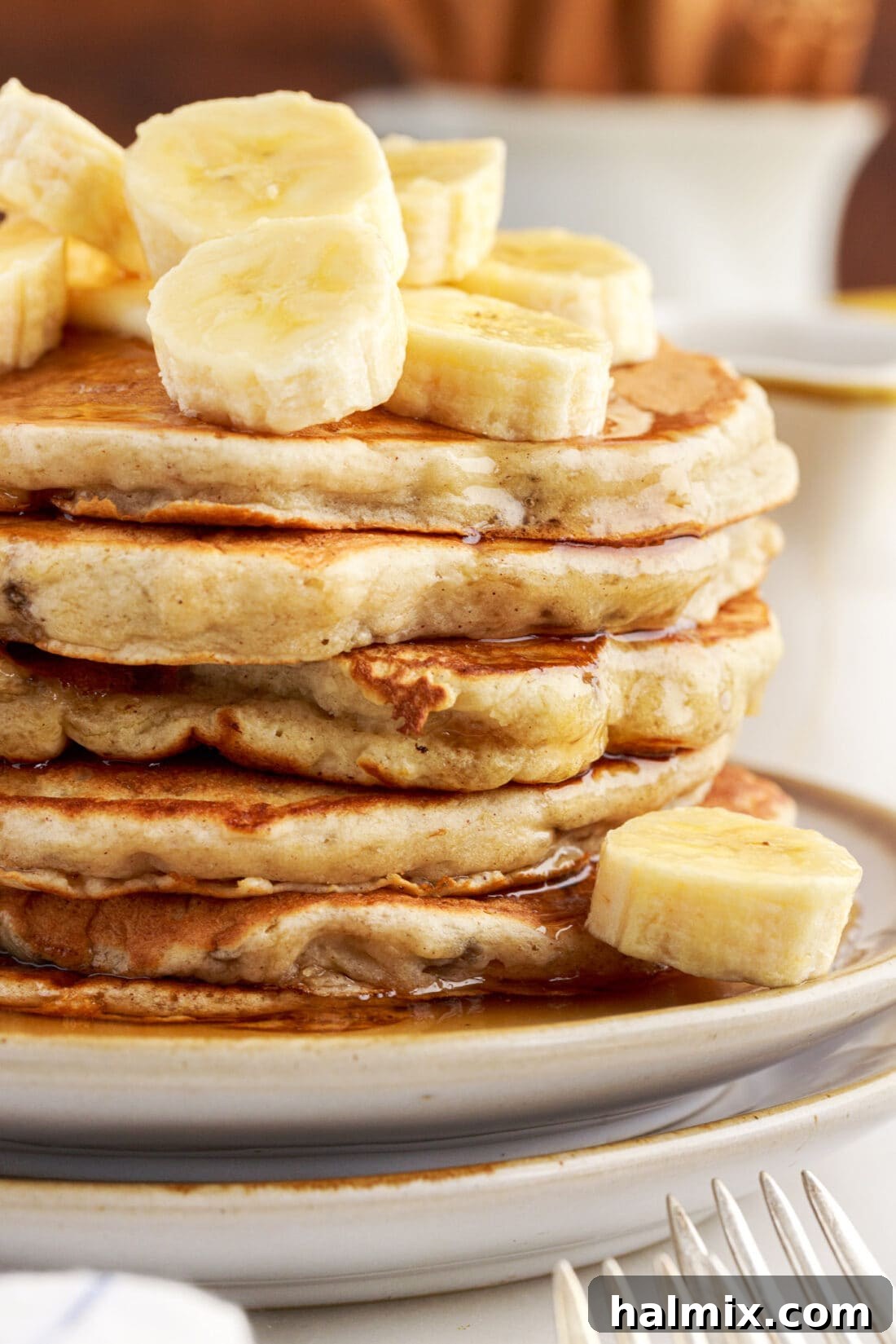 A close-up shot of a perfectly cooked stack of golden banana pancakes, inviting and delicious