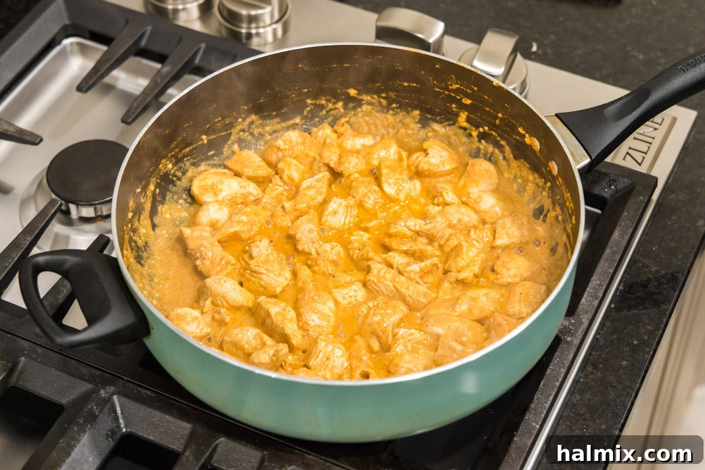 cooking chicken tikka masala in a skillet