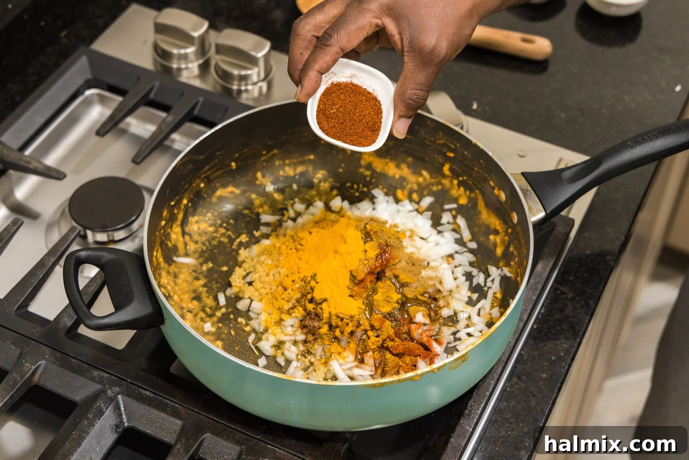 hand adding seasonings to skillet