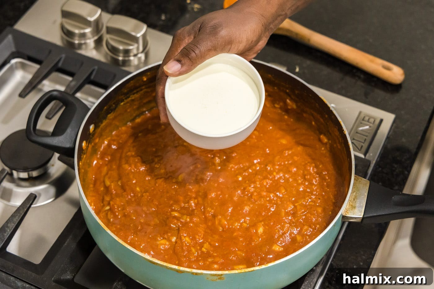adding cream to tomato sauce for chicken tikka masala