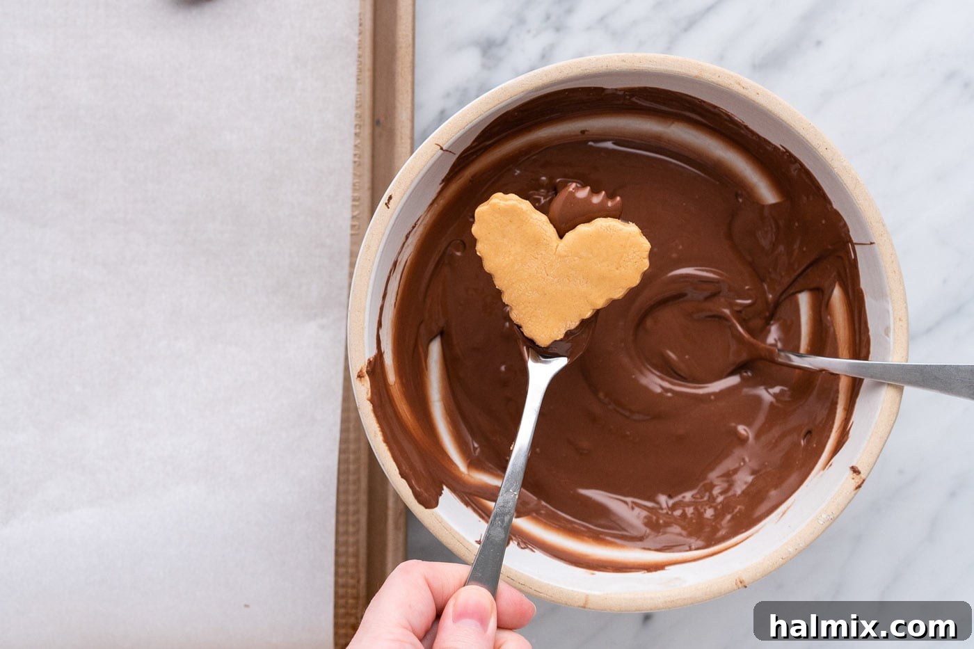 Sweetheart Chocolate Peanut Butter Treats 14 dipping peanut butter heart into melted chocolate with a fork