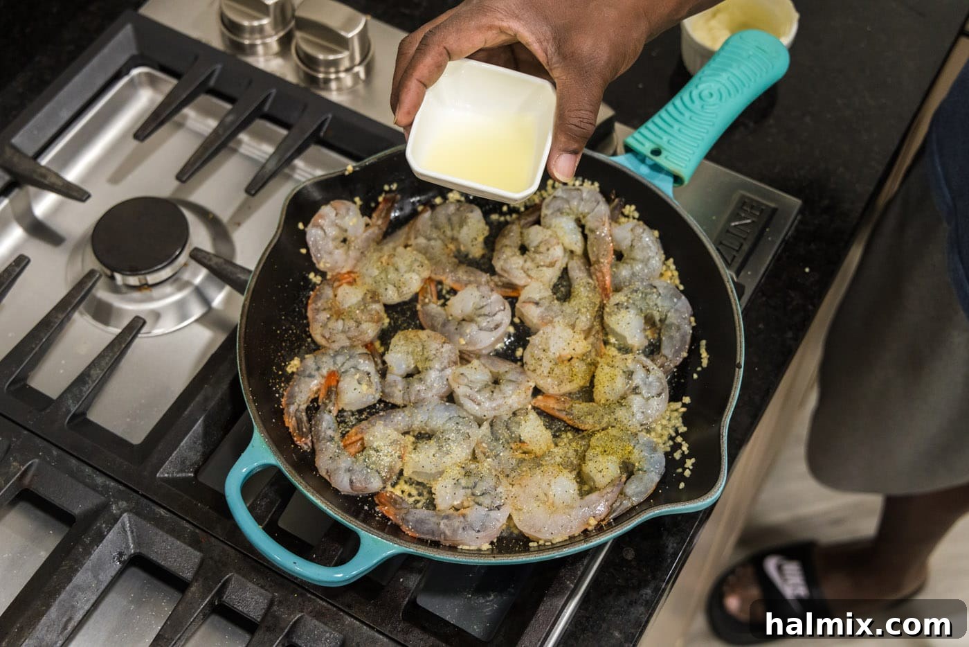 Pouring fresh lemon juice into the skillet with shrimp and butter
