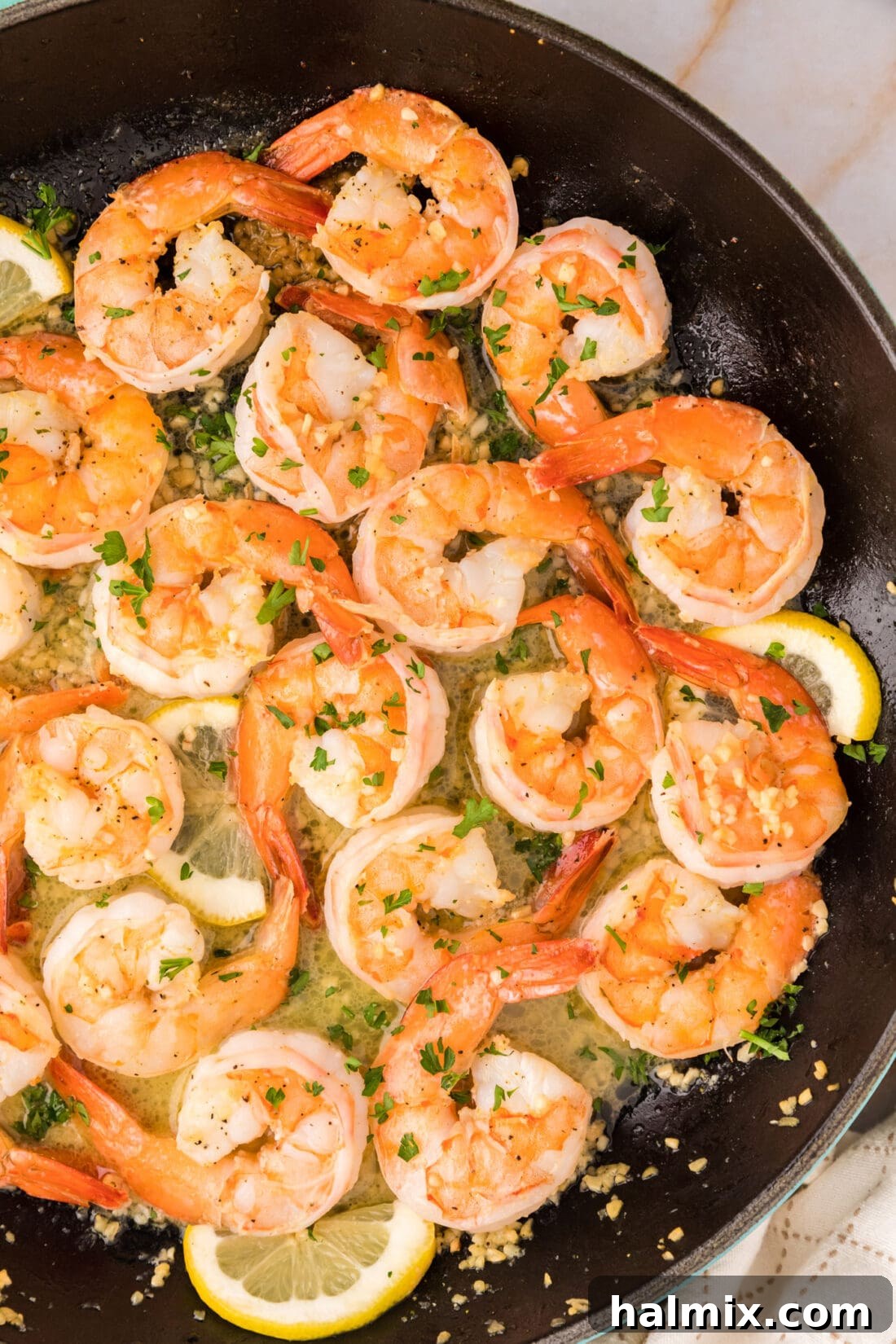 Close up overhead photo of shimmering Garlic Butter Shrimp in a hot skillet