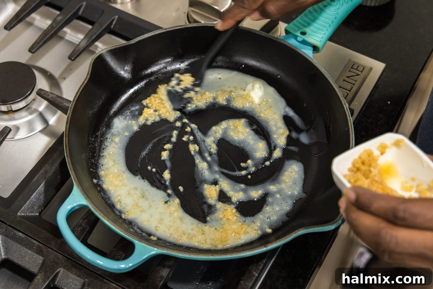 Melted butter with minced garlic sautéing in a skillet