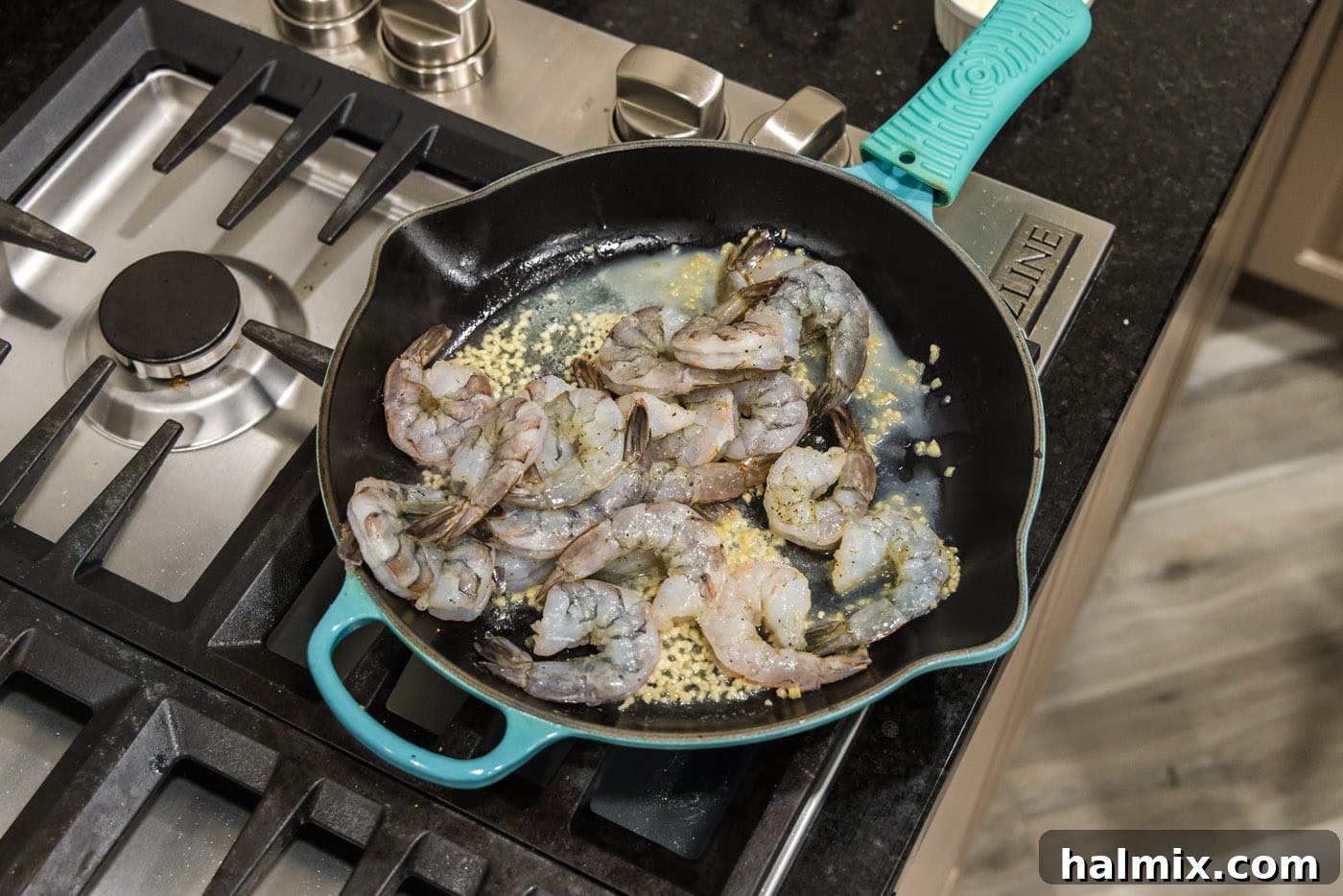 Seasoned shrimp cooking in a skillet with butter and garlic